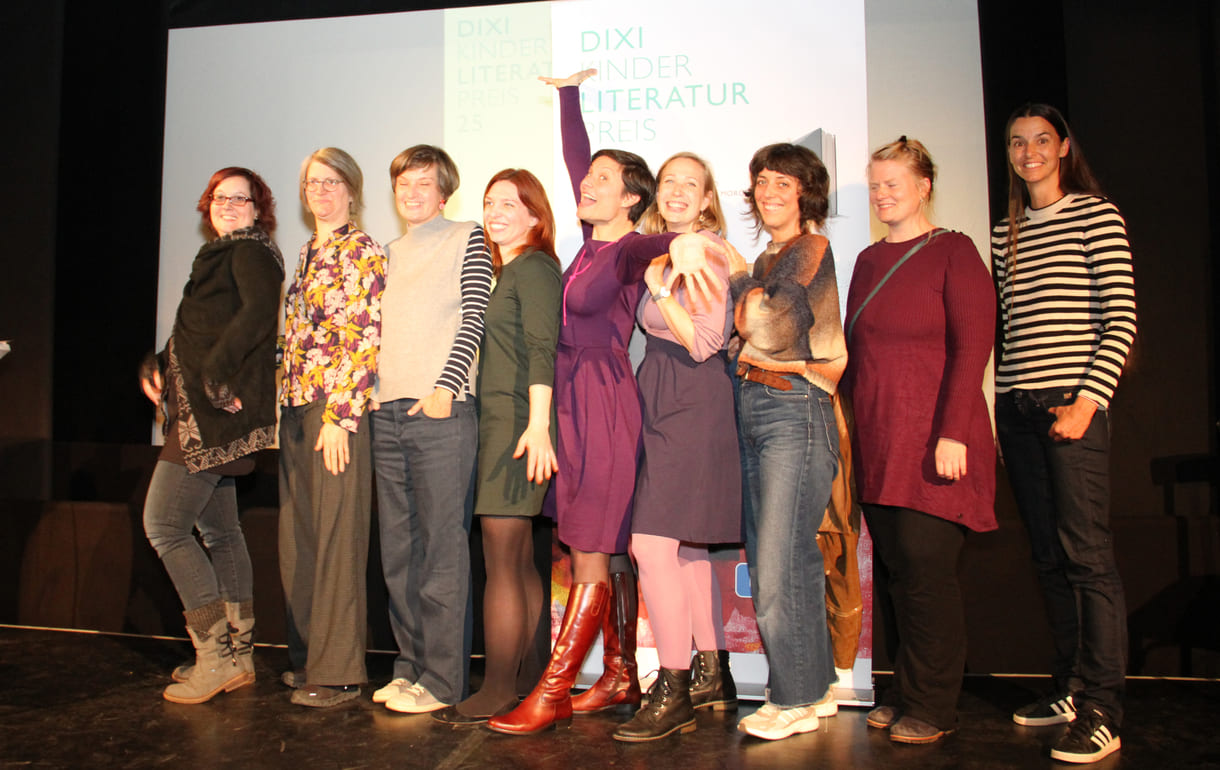 Gruppenfoto der anwesenden Preisträger:innen: Kathrin Steinberger (Text, 2003), Elisabeth Etz (Text, 2004), Leonora Leitl (Illustration, 2013), Katharina Fohringer-Hackl (Text, 2023), Lena Raubaum (Lyrik, 2016), Ella Kaspar (Text, 2021), Leonie Schlager (Illustration, 2019), Juliana Guger (Illustration, 2024), Anita Hetzenauer (Text, 2025)
