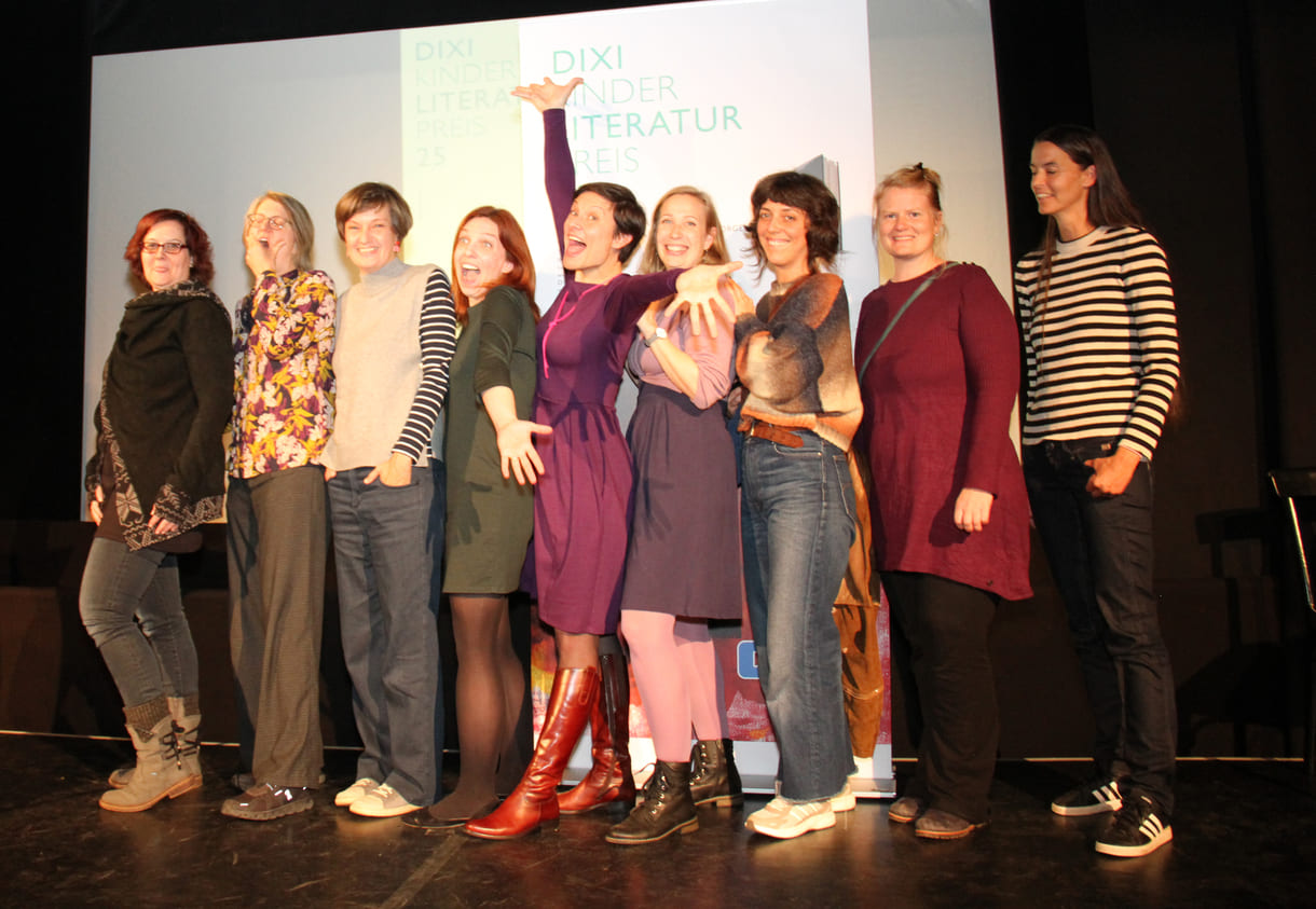 Gruppenfoto der anwesenden Preisträger:innen: Kathrin Steinberger (Text, 2003), Elisabeth Etz (Text, 2004), Leonora Leitl (Illustration, 2013), Katharina Fohringer-Hackl (Text, 2023), Lena Raubaum (Lyrik, 2016), Ella Kaspar (Text, 2021), Leonie Schlager (Illustration, 2019), Juliana Guger (Illustration, 2024), Anita Hetzenauer (Text, 2025)