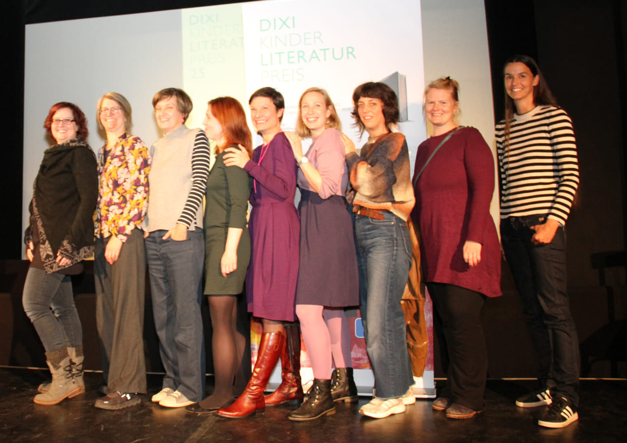 Gruppenfoto der anwesenden Preisträger:innen: Kathrin Steinberger (Text, 2003), Elisabeth Etz (Text, 2004), Leonora Leitl (Illustration, 2013), Katharina Fohringer-Hackl (Text, 2023), Lena Raubaum (Lyrik, 2016), Ella Kaspar (Text, 2021), Leonie Schlager (Illustration, 2019), Juliana Guger (Illustration, 2024), Anita Hetzenauer (Text, 2025)