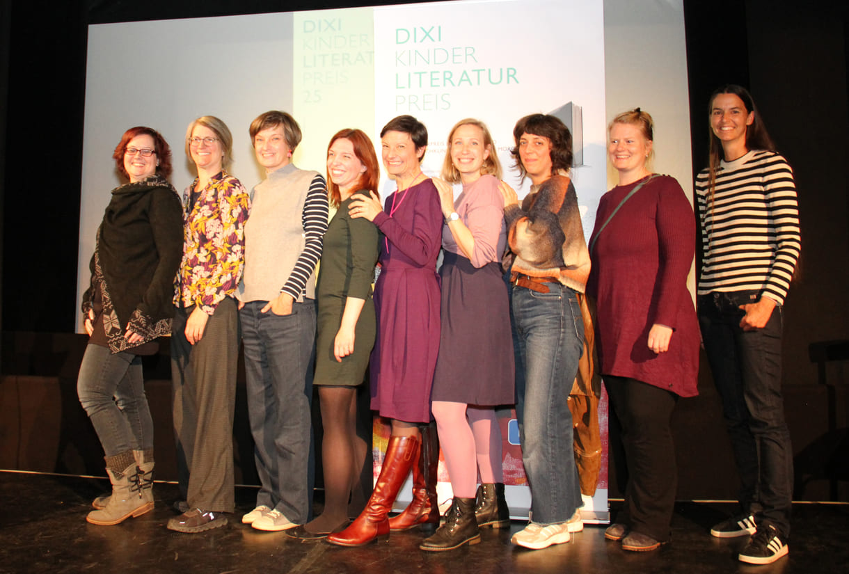 Gruppenfoto der anwesenden Preisträger:innen: Kathrin Steinberger (Text, 2003), Elisabeth Etz (Text, 2004), Leonora Leitl (Illustration, 2013), Katharina Fohringer-Hackl (Text, 2023), Lena Raubaum (Lyrik, 2016), Ella Kaspar (Text, 2021), Leonie Schlager (Illustration, 2019), Juliana Guger (Illustration, 2024), Anita Hetzenauer (Text, 2025)