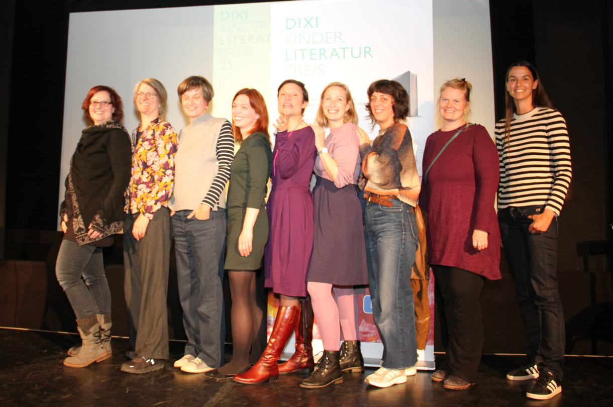 Gruppenfoto der anwesenden Preisträger:innen: Kathrin Steinberger (Text, 2003), Elisabeth Etz (Text, 2004), Leonora Leitl (Illustration, 2013), Katharina Fohringer-Hackl (Text, 2023), Lena Raubaum (Lyrik, 2016), Ella Kaspar (Text, 2021), Leonie Schlager (Illustration, 2019), Juliana Guger (Illustration, 2024), Anita Hetzenauer (Text, 2025)