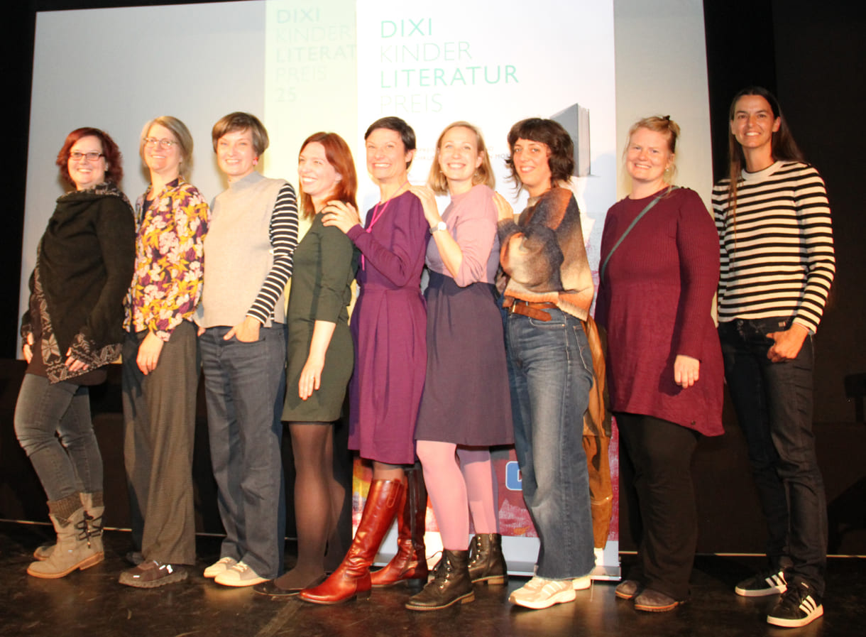 Gruppenfoto der anwesenden Preisträger:innen: Kathrin Steinberger (Text, 2003), Elisabeth Etz (Text, 2004), Leonora Leitl (Illustration, 2013), Katharina Fohringer-Hackl (Text, 2023), Lena Raubaum (Lyrik, 2016), Ella Kaspar (Text, 2021), Leonie Schlager (Illustration, 2019), Juliana Guger (Illustration, 2024), Anita Hetzenauer (Text, 2025)