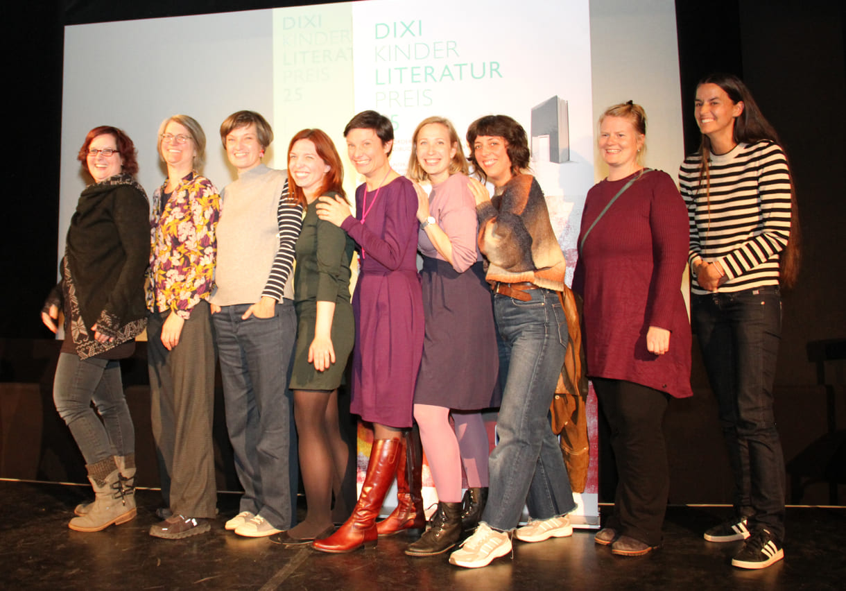 Gruppenfoto der anwesenden Preisträger:innen: Kathrin Steinberger (Text, 2003), Elisabeth Etz (Text, 2004), Leonora Leitl (Illustration, 2013), Katharina Fohringer-Hackl (Text, 2023), Lena Raubaum (Lyrik, 2016), Ella Kaspar (Text, 2021), Leonie Schlager (Illustration, 2019), Juliana Guger (Illustration, 2024), Anita Hetzenauer (Text, 2025)