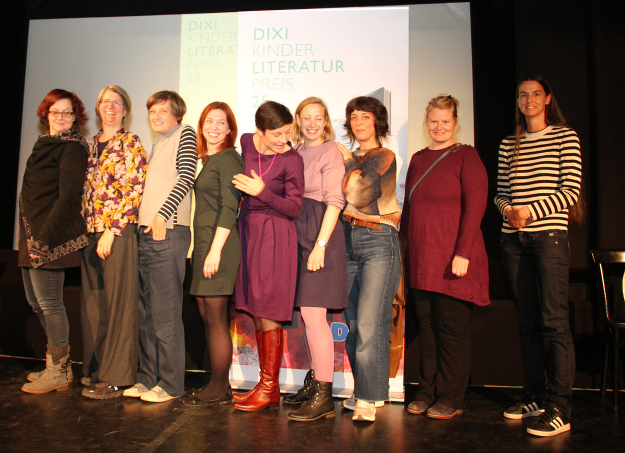 Gruppenfoto der anwesenden Preisträger:innen: Kathrin Steinberger (Text, 2003), Elisabeth Etz (Text, 2004), Leonora Leitl (Illustration, 2013), Katharina Fohringer-Hackl (Text, 2023), Lena Raubaum (Lyrik, 2016), Ella Kaspar (Text, 2021), Leonie Schlager (Illustration, 2019), Juliana Guger (Illustration, 2024), Anita Hetzenauer (Text, 2025)