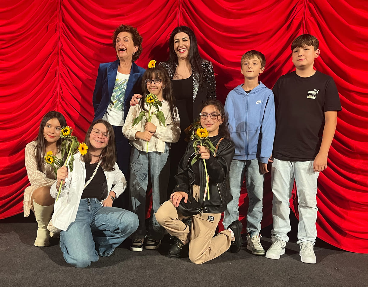 Gruppenfoto der bei der Premiere anwesenden Kinder aus dem Film mit Lehrerin und der Regisseurin