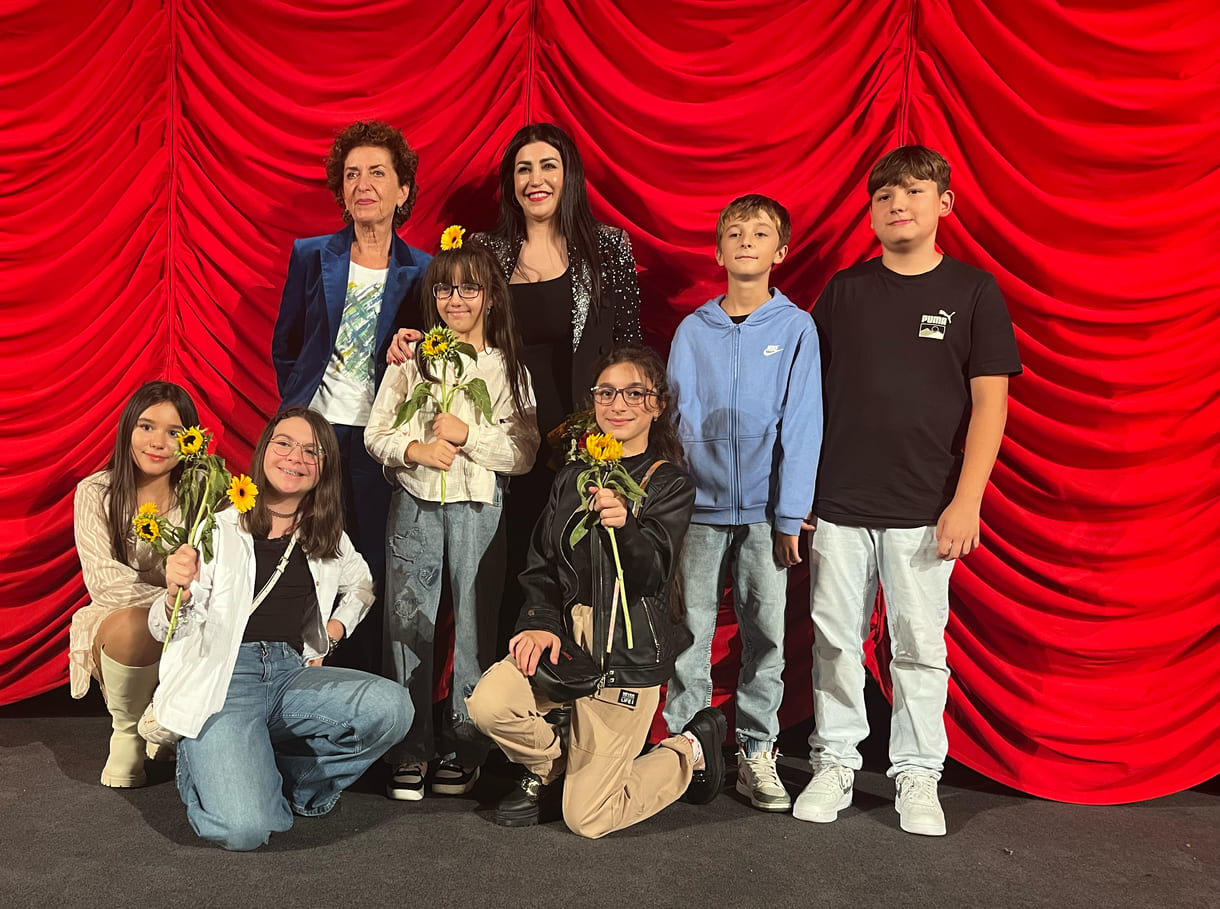 Gruppenfoto der bei der premiere anwesenden Kinder aus dem Film mit Lehrerin und der Regisseurin