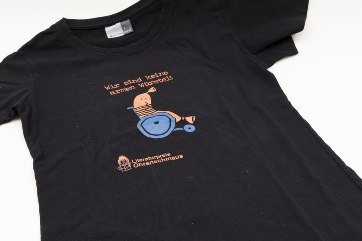 T-Shirt: Wir sind keine armen Würstel!, von Franz Joseph Huainigg zur Sammlung des Museums hinzugefügt