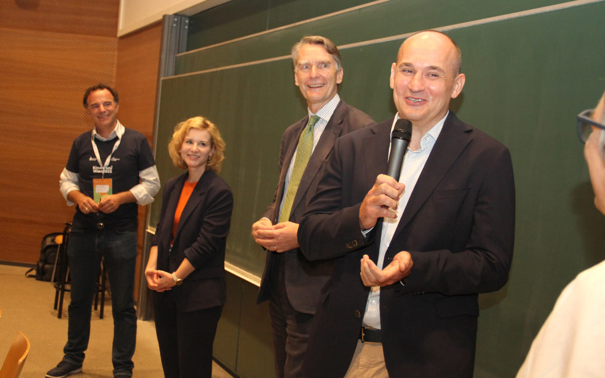 Hoher Besuch im Hörsaal - neben dem Quantenphysiker Markus Aspelmeyer die Wissenschaftsministerin Eva-Maria Holzleitner, Uni-wien-Rektor Sebastian Schütze, Sponsprvertreter Enver Siručić und ganz rechts außen nur teils zu sehen Karoline Iber, Ober-organisatorin der Kinderuni wien - von Anbeginn an
