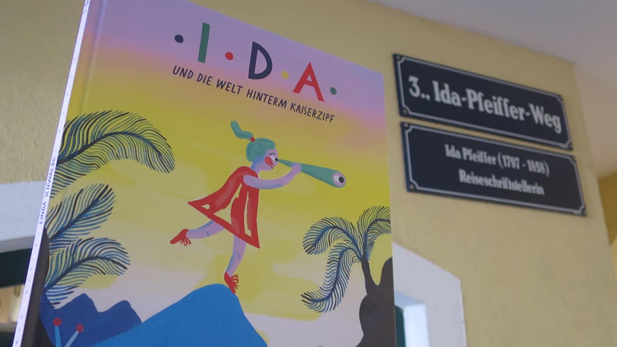 Das Bilderbuch über Ida Pfeffier und Straßenschilder eines Kürzest-Wegs, der nach der Reiseschriftstellerin benannt ist
