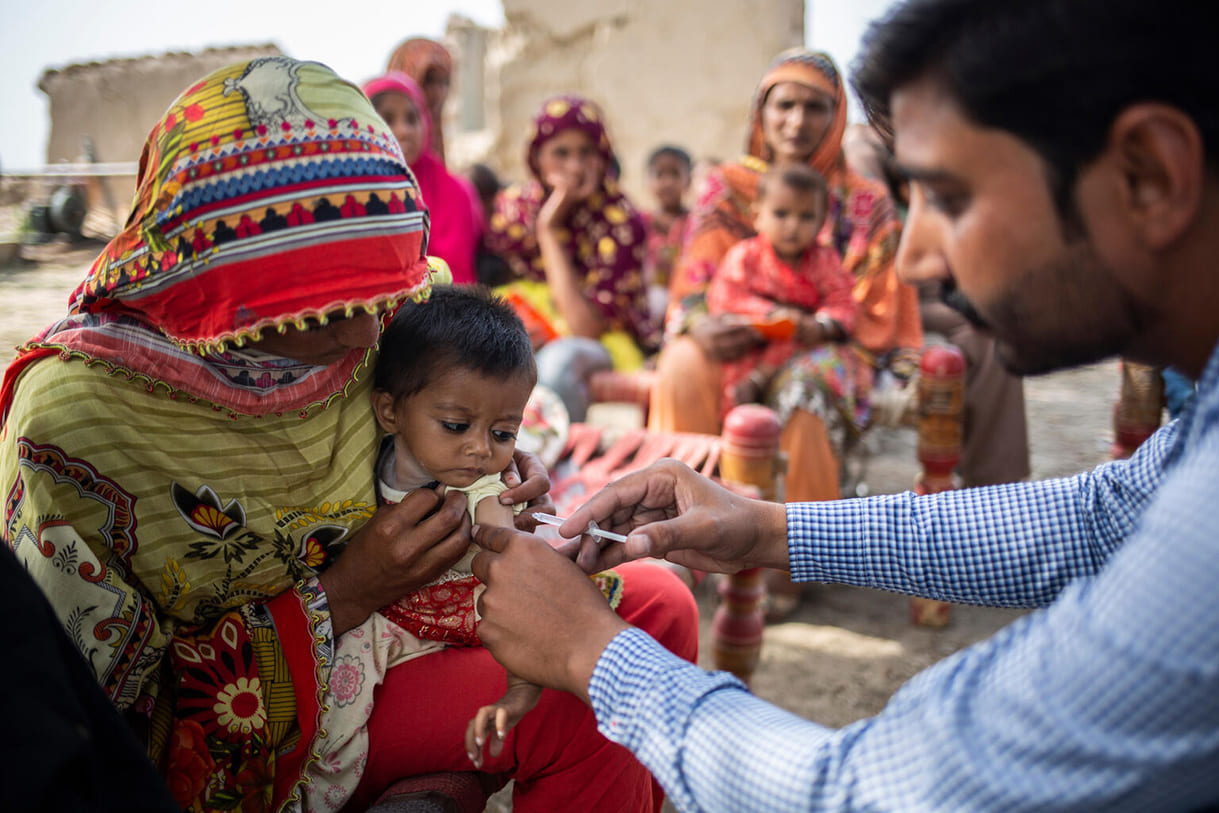 Impfarzt Muhammad Shahbaz impft hier am 11. April 2023 viele Kinder im Dorf Masta Kay in Kasur (Provinz Punjab, Pakistan) gegen Masern - hier gerade die einjährige Ramazana