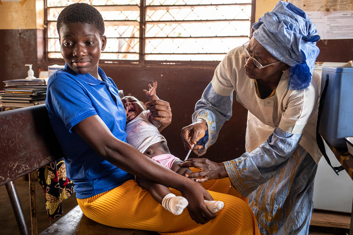 Am 22. Februar 2023 wird in Bangui, Zentralafrikanische Republik, ein kleines Mädchen von seiner Mutter gehalten, während es von der Gesundheitshelferin Celestine Koursany im Centre de Santé Urbain (Städtisches Gesundheitszentrum) im Stadtteil Lakouanga geimpft wird.