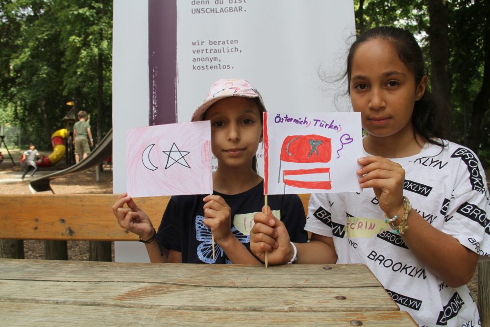 Einige Kinder zeigen ihre selbst gemalten Kinderrechte-Fahnen