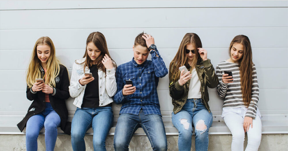 Jugendliche, die intensiv auf SmartPhones schauen