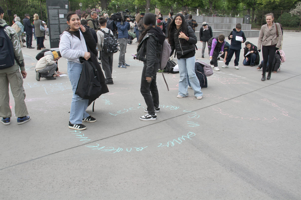 Jugendliche malen mit Kreide Sprüche auf den Boden