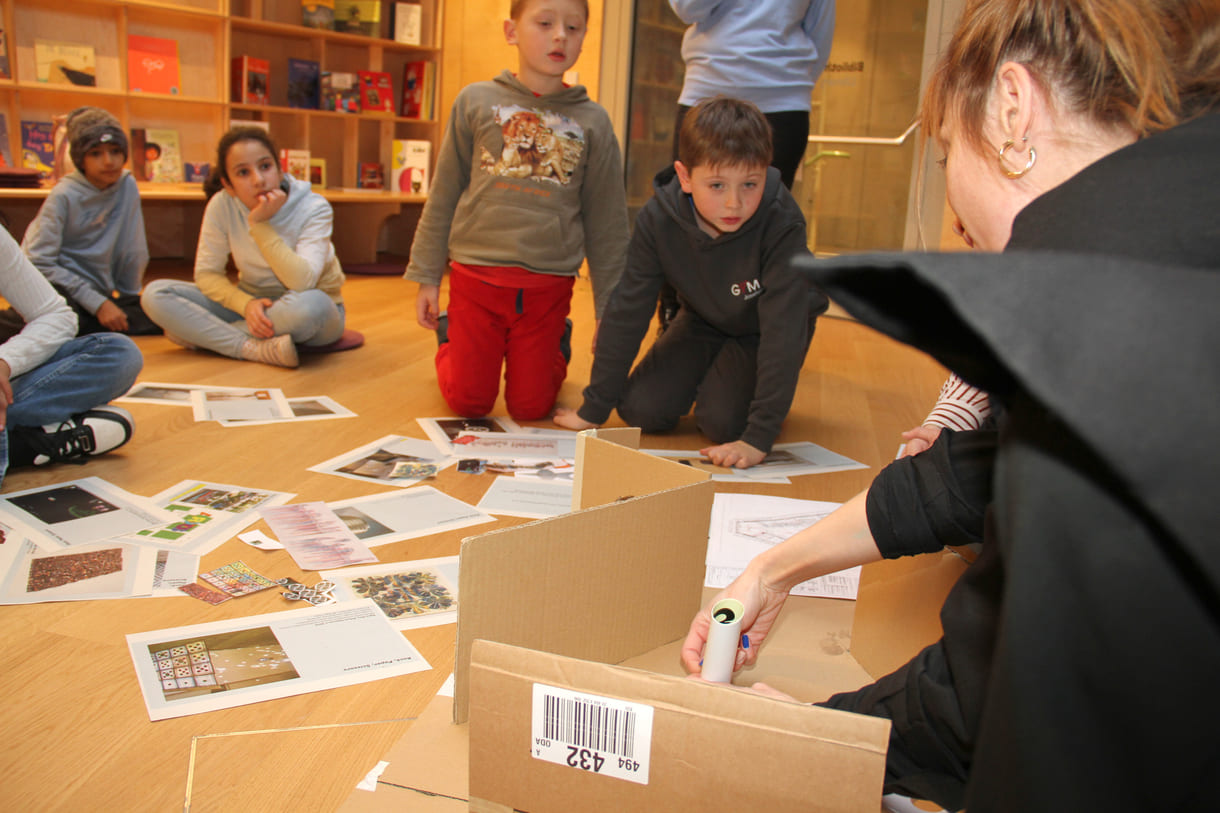 Rund um ein Karton-Modell des großen Ausstellungsraumes