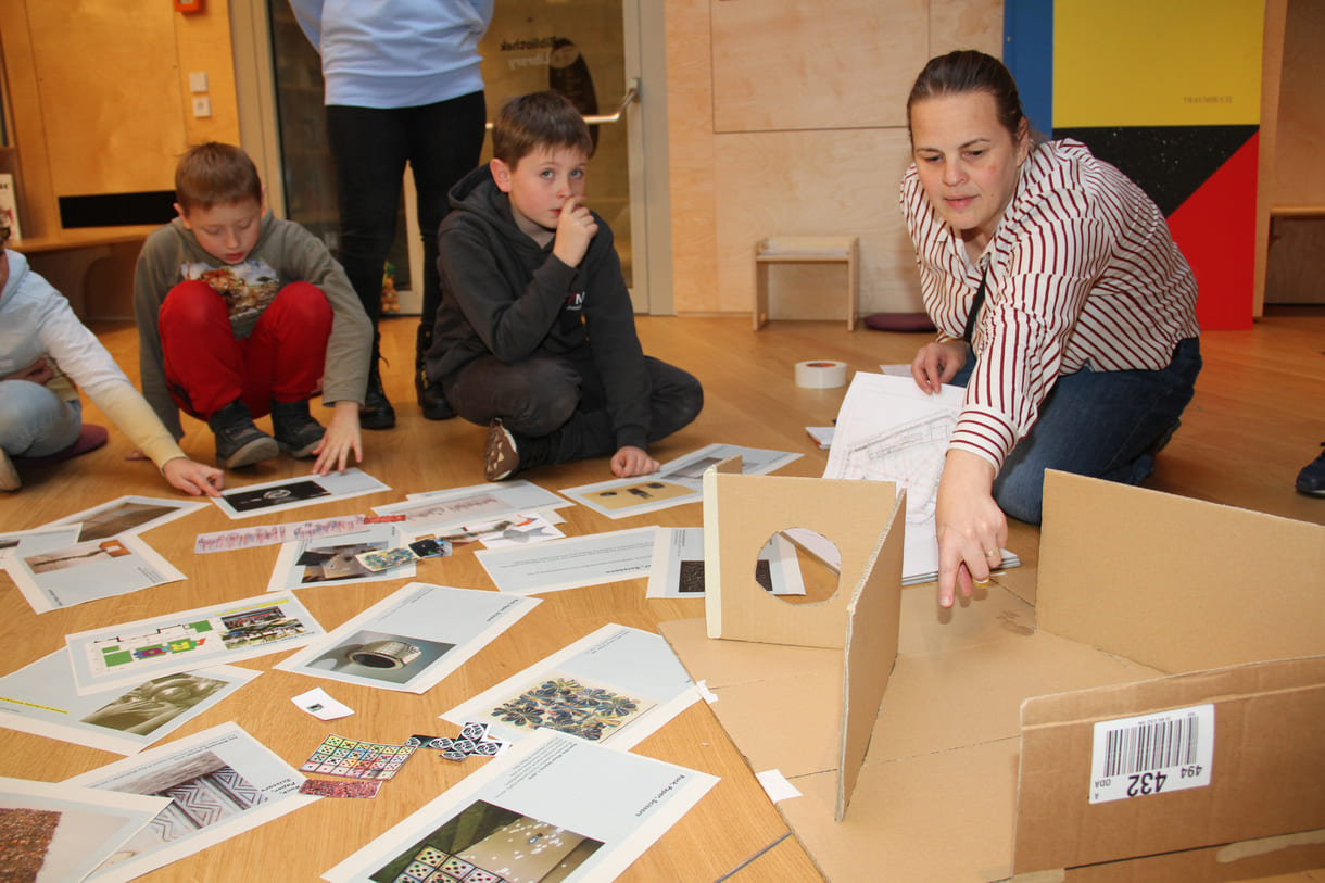 Rund um ein Karton-Modell des großen Ausstellungsraumes