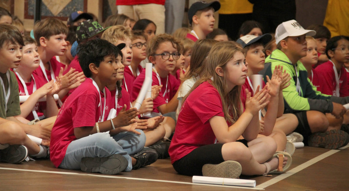 Kinder applaudieren bei den Dankes an lehrende, Mitarbeiter:innnen und Organisator:innen