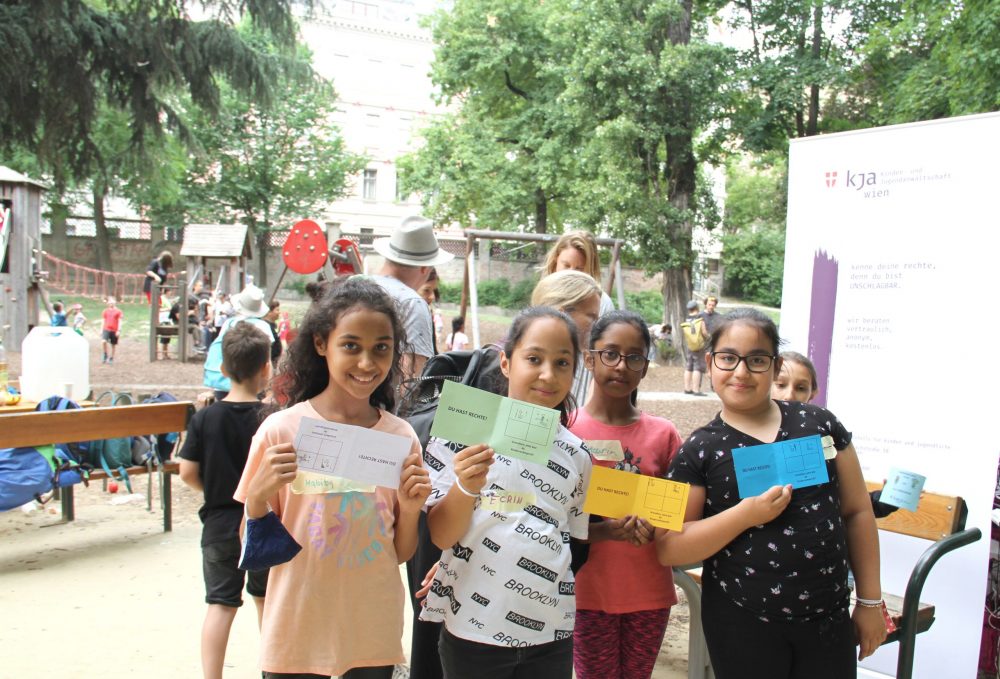 Einige Kinder zeigen ihren Kinderrechte-Pass mit Stempeln für absolvierte Stationen