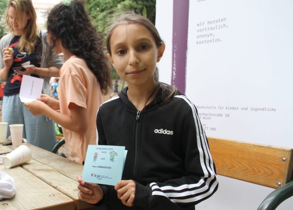 Einige Kinder zeigen ihren Kinderrechte-Pass mit Stempeln für absolvierte Stationen