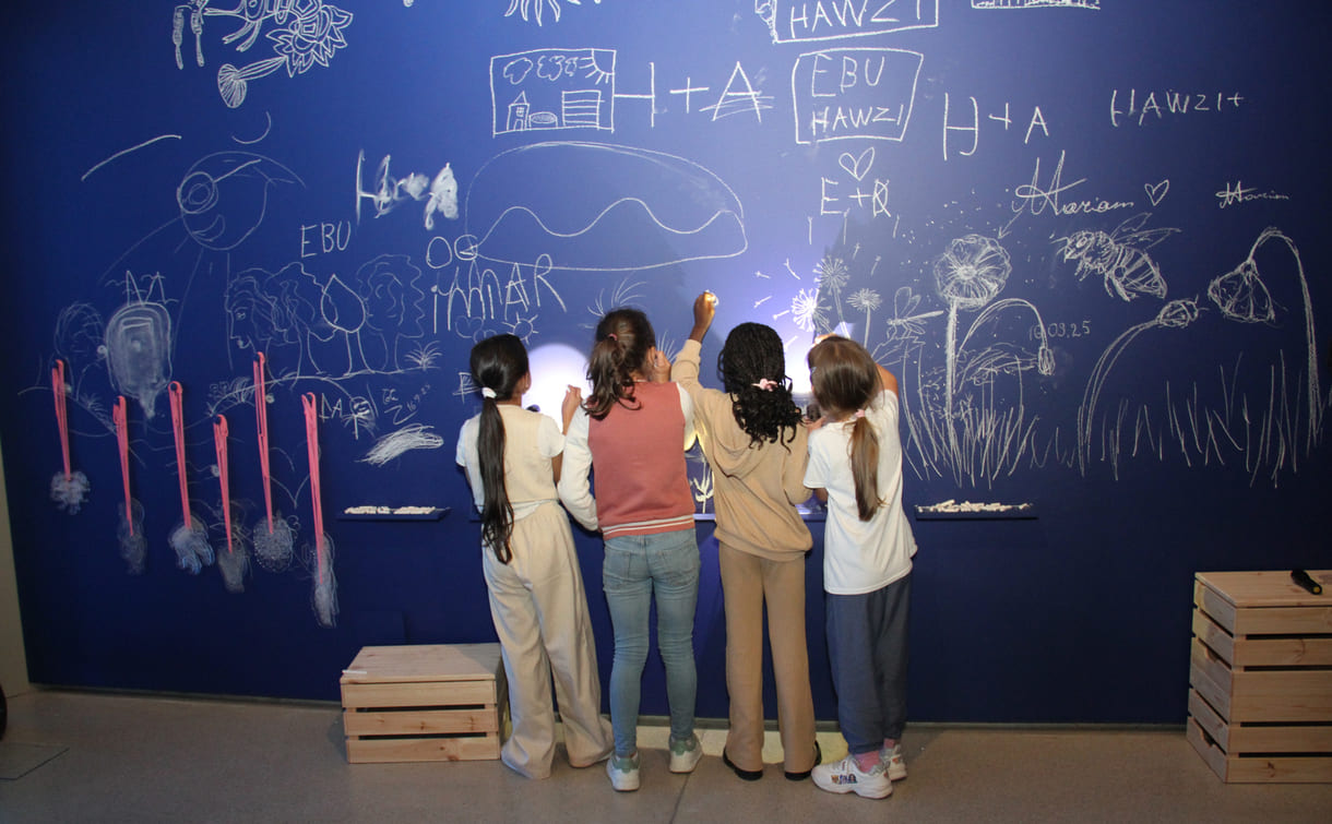 In der Ausstellungshalle ist eine ganze Wand für Kreidezeichnung der Besucher:innen reserviert