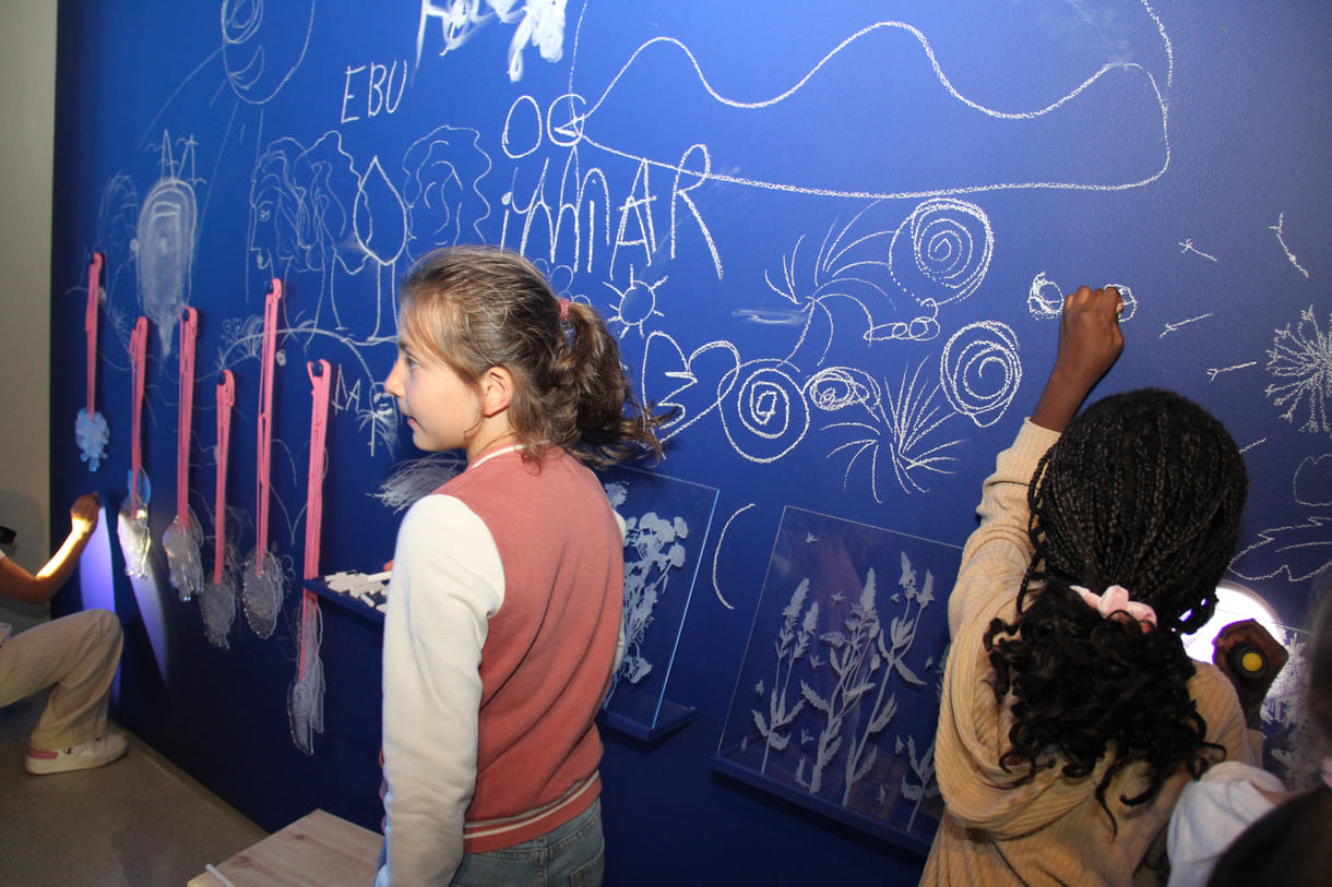 In der Ausstellungshalle ist eine ganze Wand für Kreidezeichnung der Besucher:innen reserviert