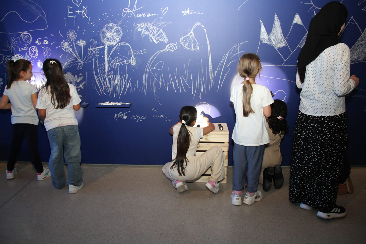 In der Ausstellungshalle ist eine ganze Wand für Kreidezeichnung der Besucher:innen reserviert