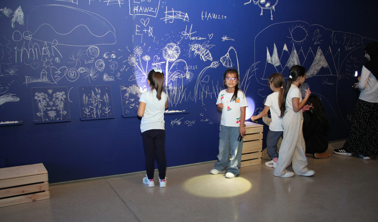 In der Ausstellungshalle ist eine ganze Wand für Kreidezeichnung der Besucher:innen reserviert