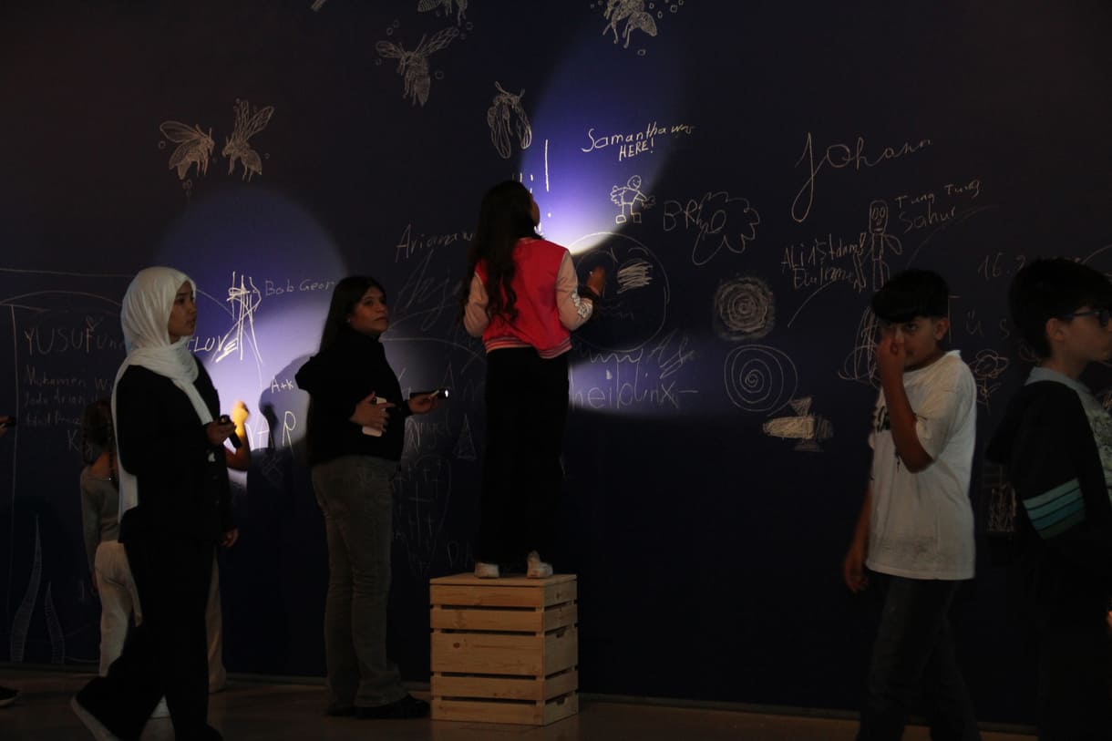 In der Ausstellungshalle ist eine ganze Wand für Kreidezeichnung der Besucher:innen reserviert