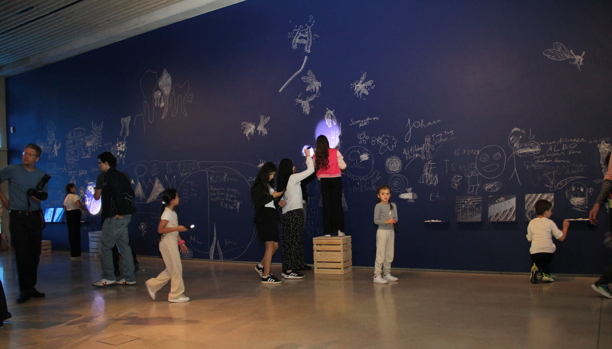 In der Ausstellungshalle ist eine ganze Wand für Kreidezeichnung der Besucher:innen reserviert