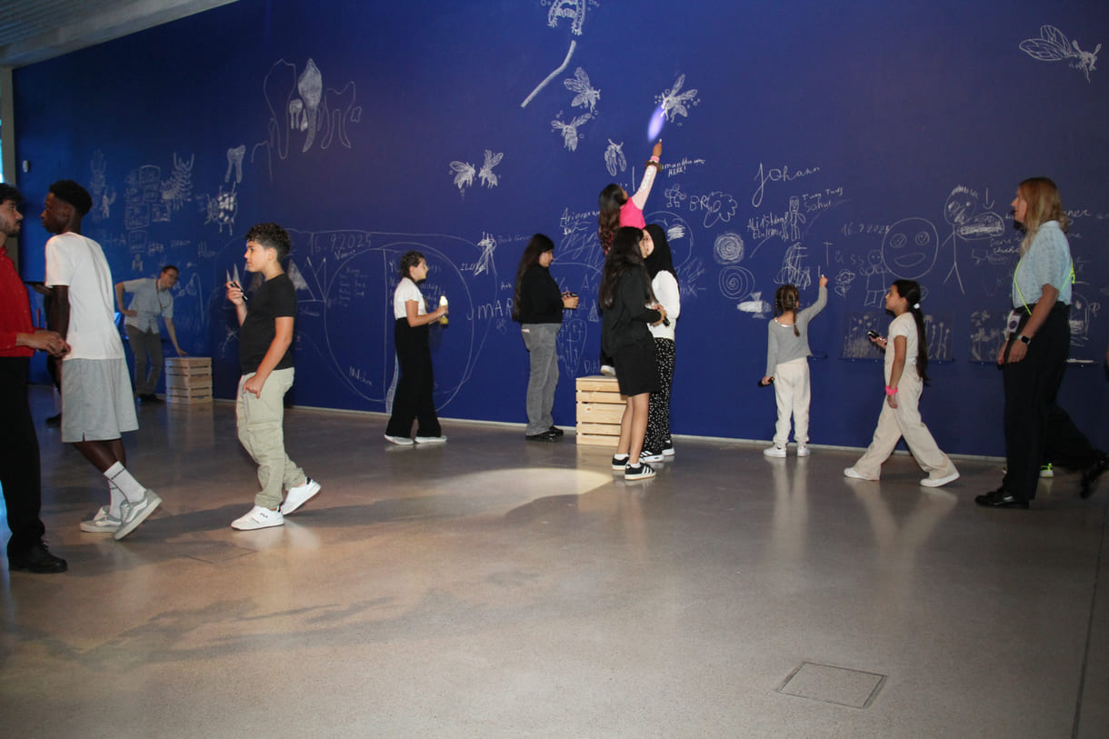 In der Ausstellungshalle ist eine ganze Wand für Kreidezeichnung der Besucher:innen reserviert