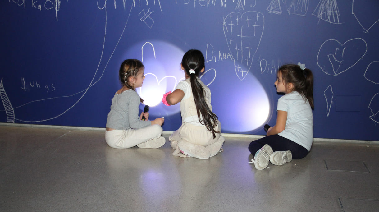 In der Ausstellungshalle ist eine ganze Wand für Kreidezeichnung der Besucher:innen reserviert