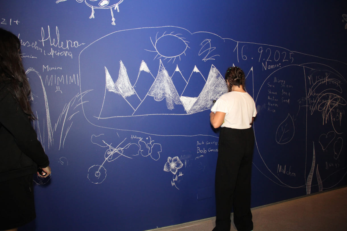 In der Ausstellungshalle ist eine ganze Wand für Kreidezeichnung der Besucher:innen reserviert