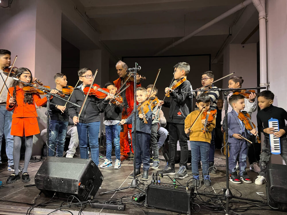 Musik-Kinder beim gemeinsamen Auftritt mit ihrem Lehrer