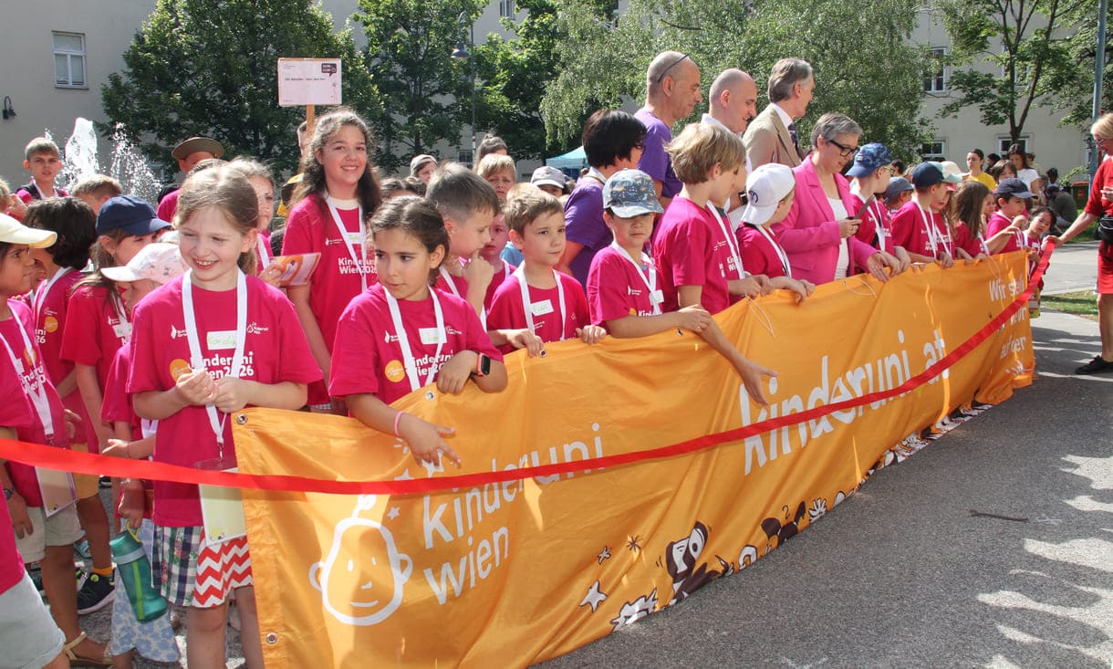 Jung-Studierende und Alt-Lehrende sowie die Organisatorin und der Hauptsponsor mit dem großen Kinderuni Wien-Transparent