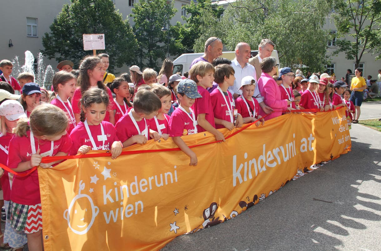 Jung-Studierende und Alt-Lehrende sowie die Organisatorin und der Hauptsponsor mit dem großen Kinderuni Wien-Transparent