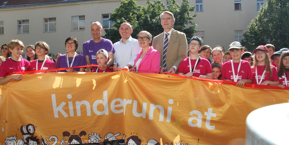 Jung-Studierende und Alt-Lehrende sowie die Organisatorin und der Hauptsponsor mit dem großen Kinderuni Wien-Transparent