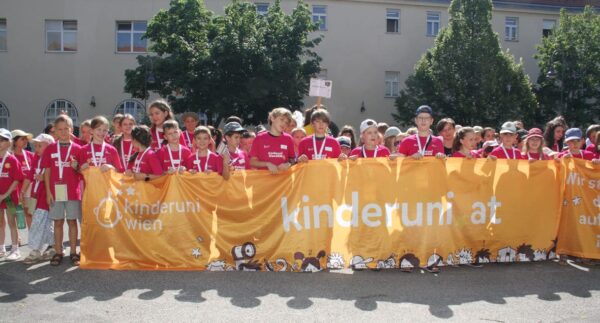 Jungstudierende mit dem großen Kinderuni Wien-Transparent