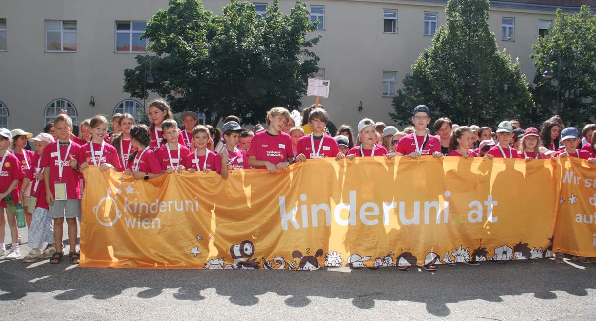 Jungstudierende mit dem großen Kinderuni Wien-Transparent