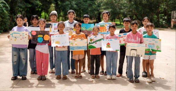 Kinder zeigen ihre gezeichneten Bilder von einer besseren Zukunft (8. Juli 2025 in Buon Tuor, Dak Lak, Vietnam, veranstaltet von einem mobilen Bibliotheksprogramm)