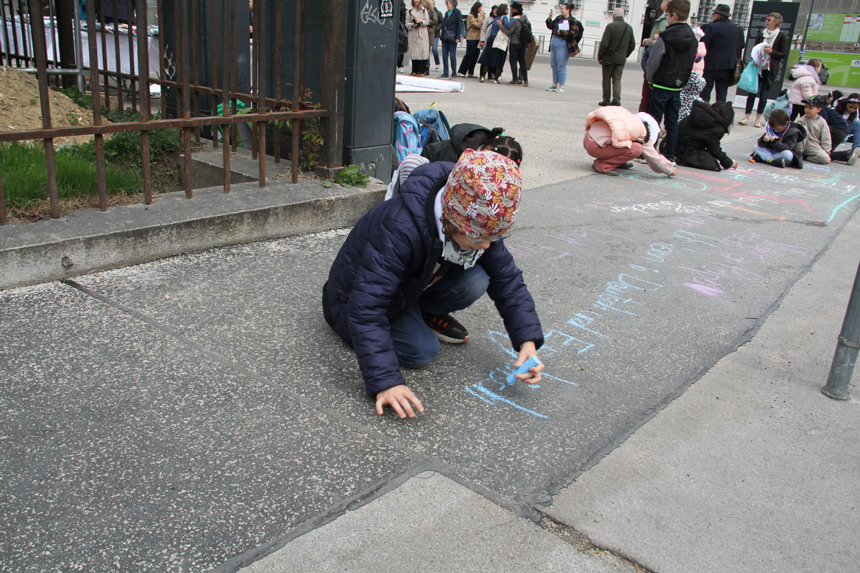 Kinder schreiben Kreidesprüche rund ums Lesen auf den Boden