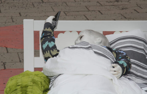 Puppe im Kinderbett starrt aufs Handy - aktionistisch machte der Unicef-Jugendbeirat auf die eigenen Forderungen in Sachen digitaler Kinderschutz aufmerksam