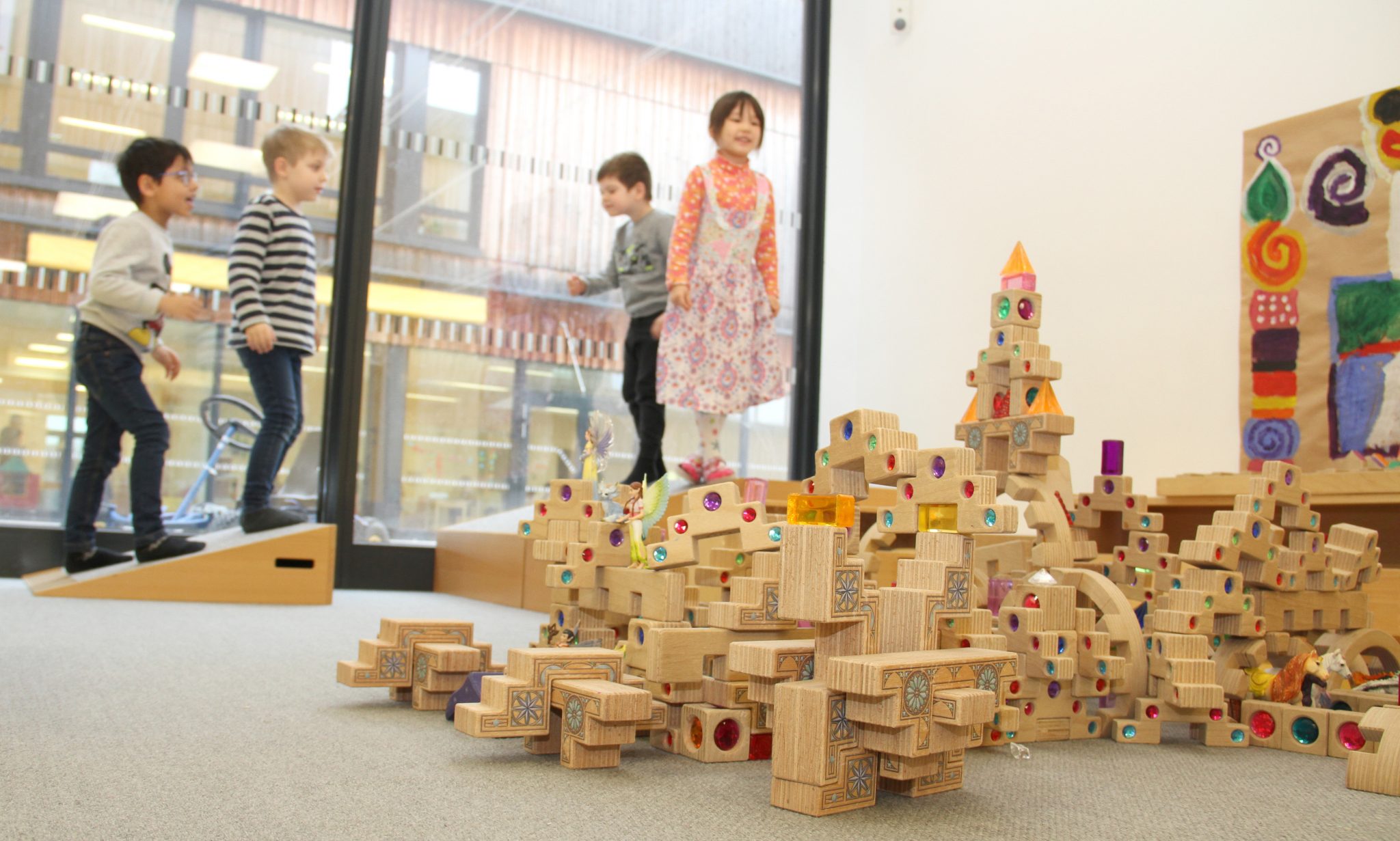 Kinder in einem Kindergarten, gehen über Hindernisse und Bausteine