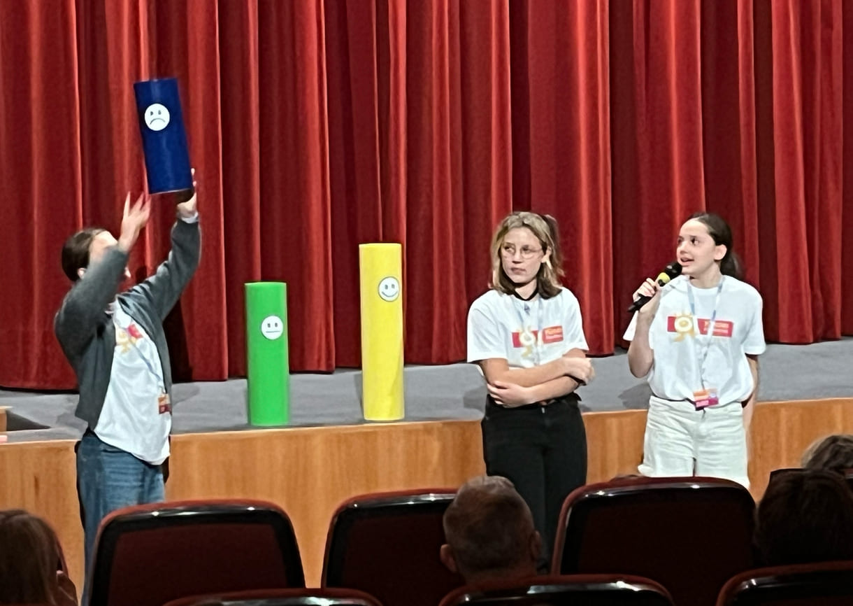 Kinderjury-Mitglieder erklären, wie das Publikum mit dem Eintrittskarten-Abschnitt abstimmen kann