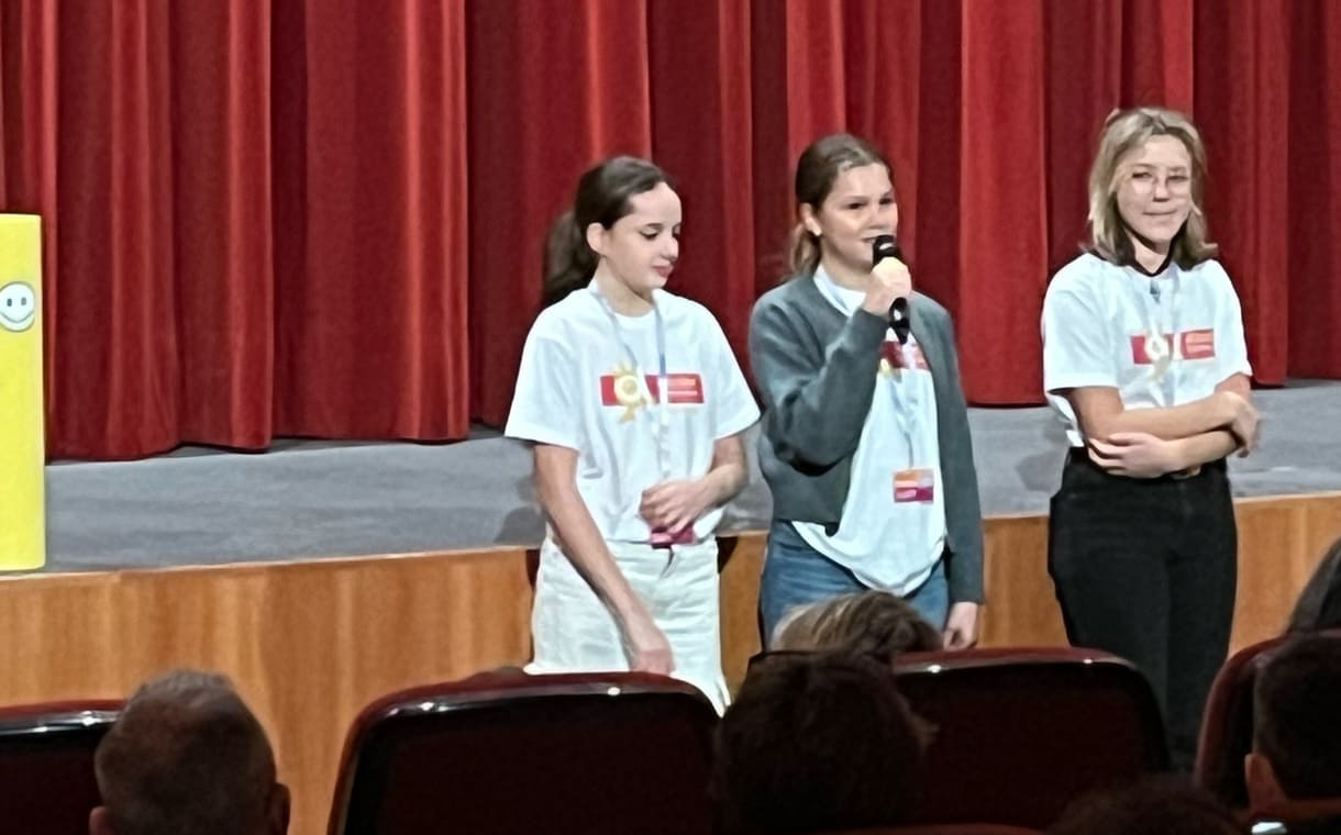 Kinderjury-Mitglieder erklären, wie das Publikum mit dem Eintrittskarten-Abschnitt abstimmen kann