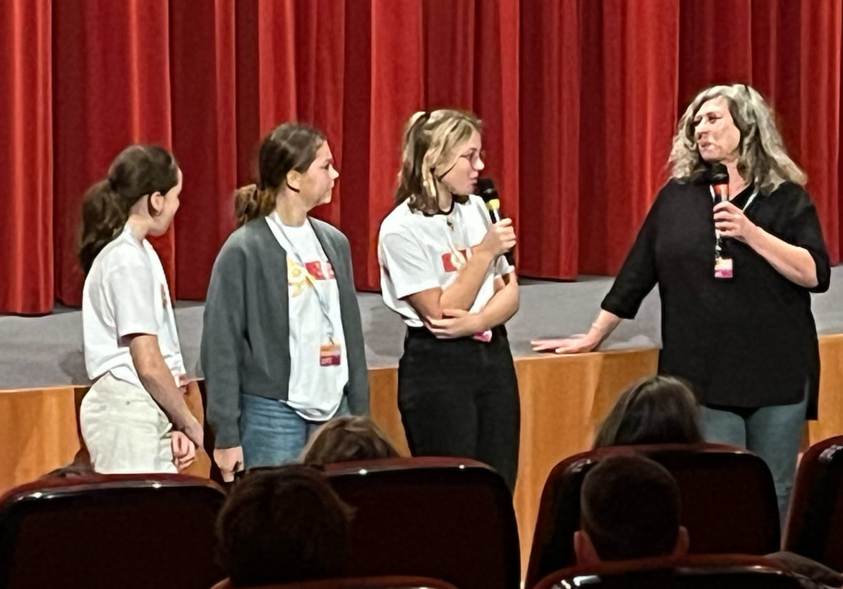 Kinderjury-Mitglieder erklären, wie das Publikum mit dem Eintrittskarten-Abschnitt abstimmen kann