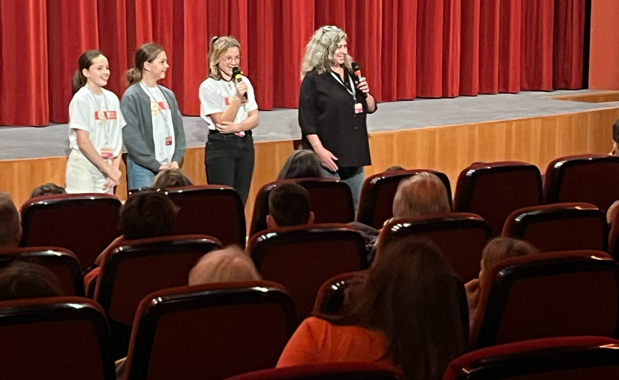 Kinderjury-Mitglieder erklären, wie das Publikum mit dem Eintrittskarten-Abschnitt abstimmen kann