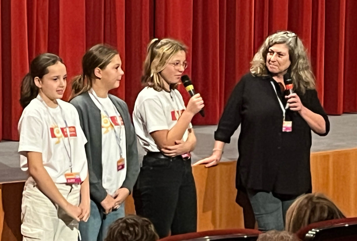 Kinderjury-Mitglieder erklären, wie das Publikum mit dem Eintrittskarten-Abschnitt abstimmen kann