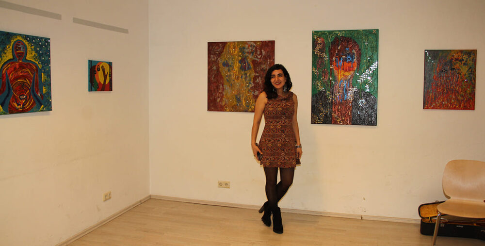 Die Künstlerin Maryam Haidari mit Bildern ihrer Ausstellung