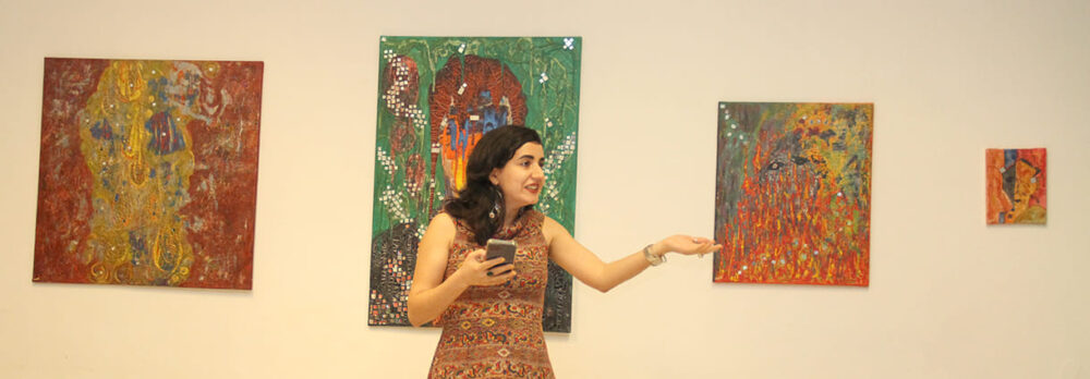 Die Künstlerin Maryam Haidari vor Bildern ihrer Ausstellung bei der Eröffnungsrede