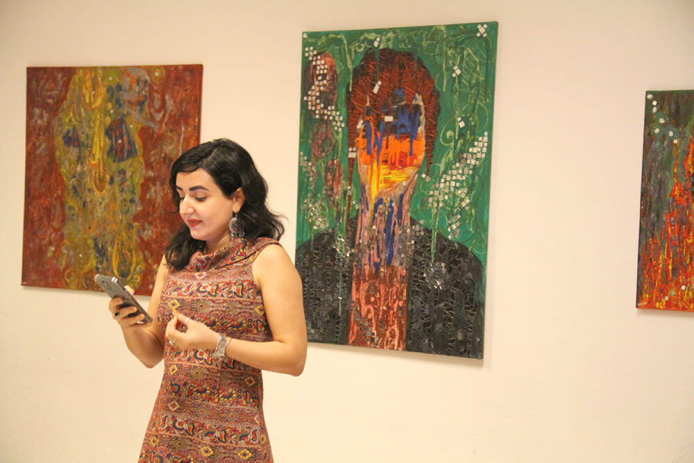 Die Künstlerin Maryam Haidari vor Bildern ihrer Ausstellung bei der Eröffnungsrede